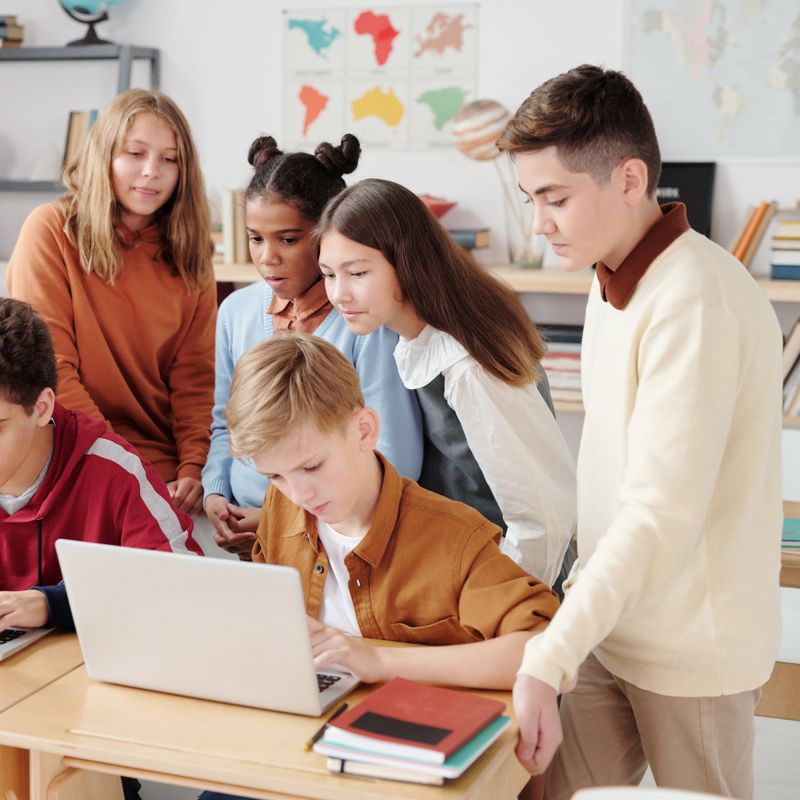 Diverse students collaborating together on a learning activity, guided by a teacher